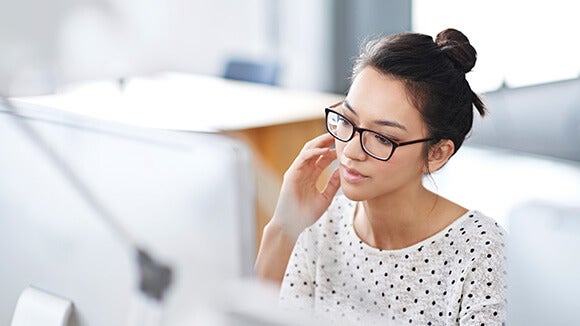 vrouw met bril achter desktop vrouw met bril achter desktop