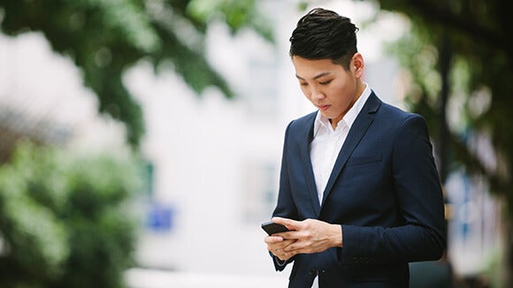 zakelijk geklede man kijkt op telefoon zakelijk geklede man kijkt op telefoon
