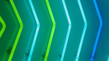 Groene en blauwe lichtbuizen gebogen in de vorm van pijl