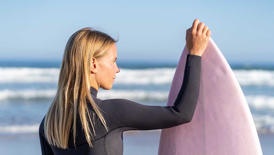 Vrouw die een surfboard vast heeft